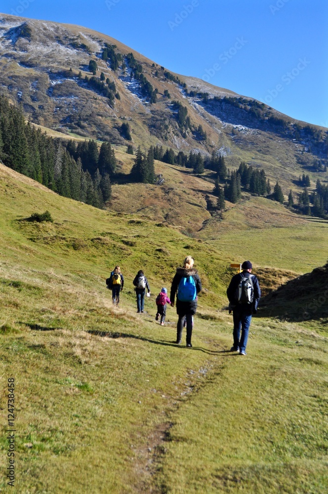 Wandergruppe wandert im Herbst auf dem Wanderweg in den Schweizer Alpen / Berge