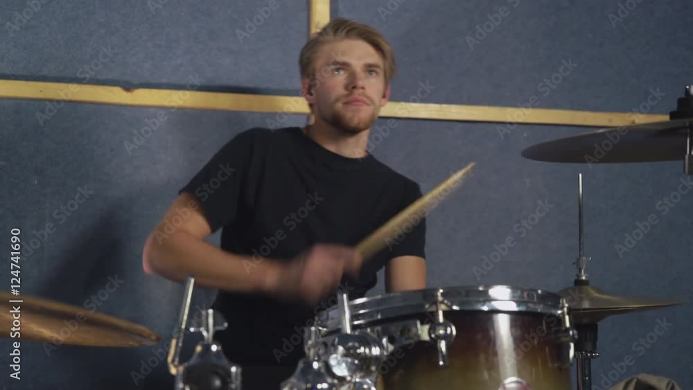 Drummer playing on the drum set beat rhythm using drumsticks. Portrait adult caucasian musician plays performance singing on the concert or rehearsal. Caucasian instrumentalist on the repetition. Drummer playing on the drum set beat rhythm using drumsticks. Portrait adult caucasian musician plays performance singing on the concert or rehearsal. Caucasian instrumentalist on the repetition.