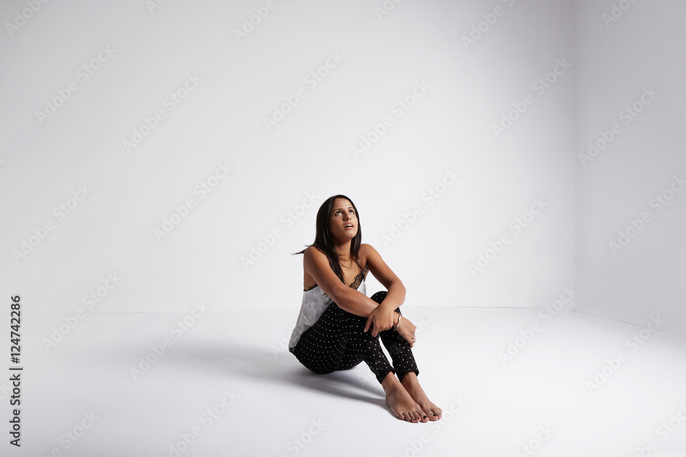 Fototapeta premium wondering woman sits on the floor and watching up