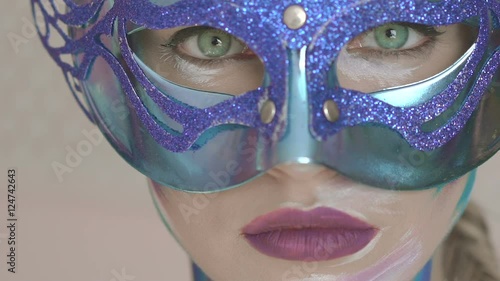 Green eyes look of the mysterious girl in venetian mask with winter art make up photo