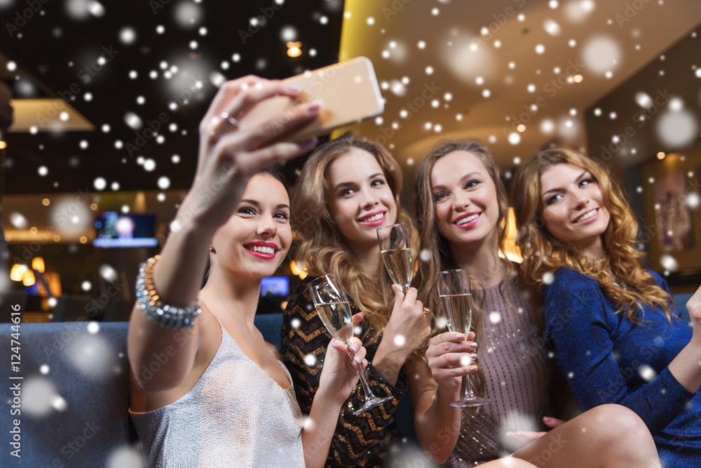 women with champagne taking selfie at night club