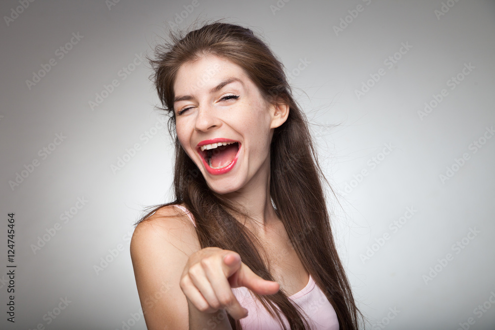 Flirtatious girl pointing on camera and winking. Flirtatious girl pointing on camera and winking.