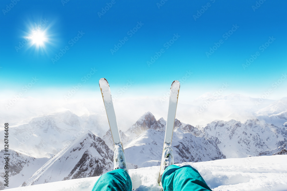 Fototapeta premium Detail of alpine skier legs, watching the valley panorama