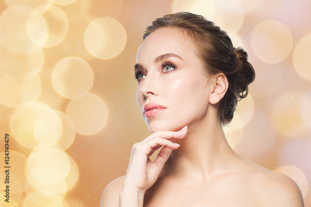 Fototapeta premium beautiful woman touching her face over lights