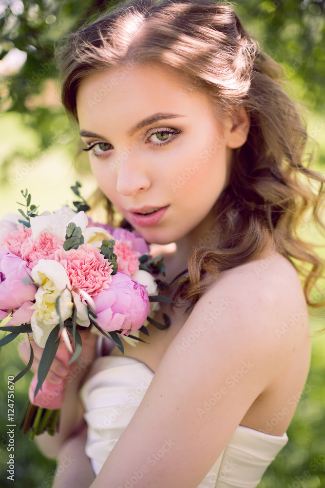 young bride in white dress and with a bouquet in the summer young bride in white dress and with a bouquet in the summer