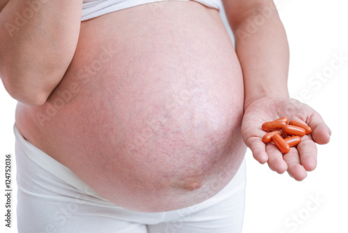 pregnant woman taking medicines on white background.