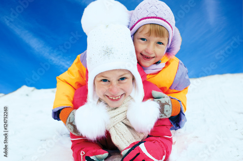 Children ride from the snow slide. Winter fun