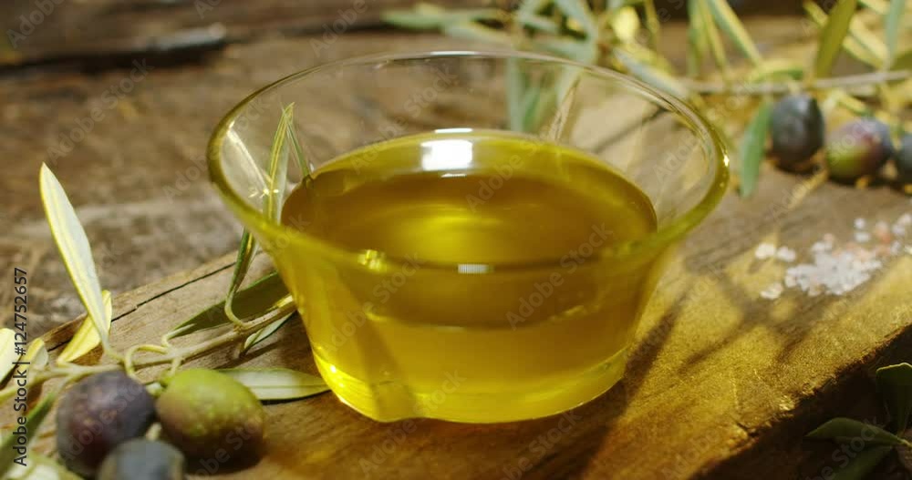Genuine Italian organic oil cold pressed in slowmotion falls on organic bread. concept of nature and healthy food, healthy and natural. fresh olives and Tuscan Italian oil Genuine Italian organic oil cold pressed in slowmotion falls on organic bread. concept of nature and healthy food, healthy and natural. fresh olives and Tuscan Italian oil