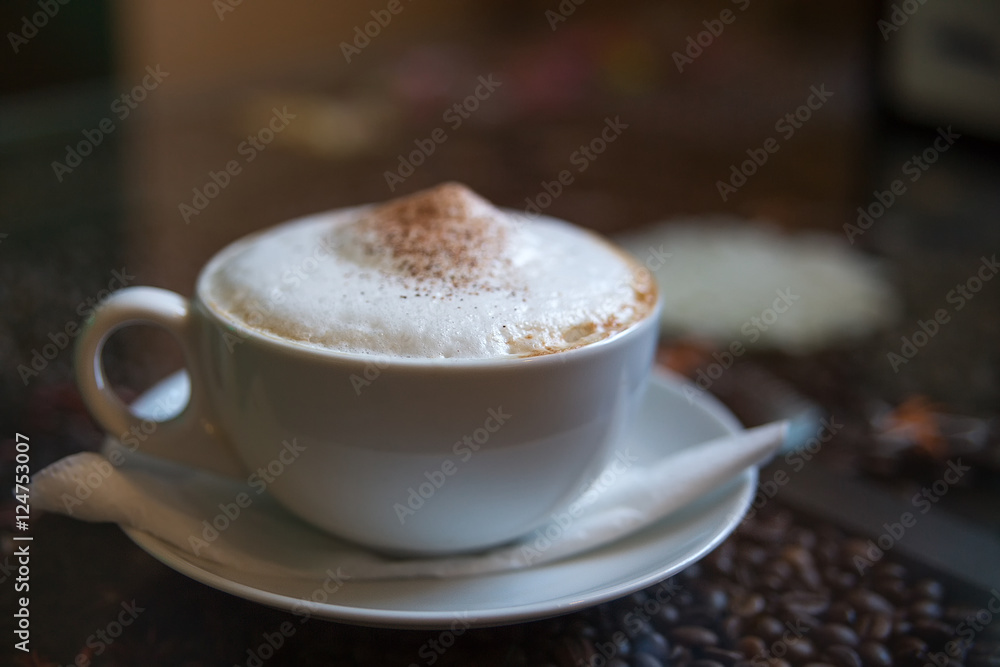 Cup of cappuccino on the table. in a dark café. soft focus. Cup of cappuccino on the table. in a dark café. soft focus.