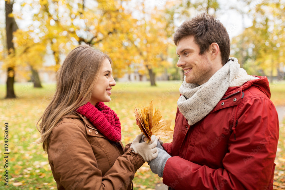 Fototapeta premium happy couple with maple leaves in autumn park