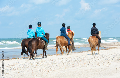 Kinder reiten mit Ponys am Strand photo
