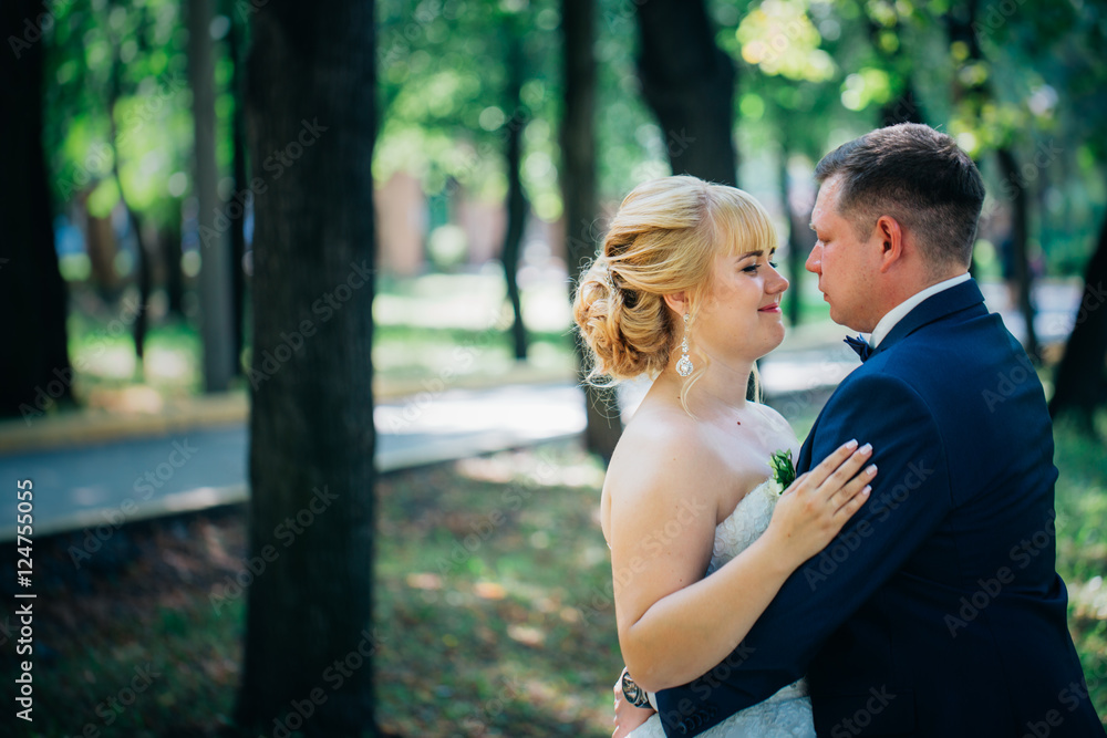Fototapeta premium para młodej i pana młodego na tle drzew w parku