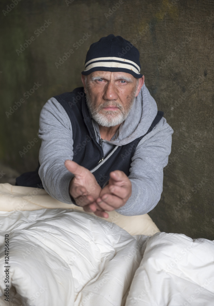 Portrait image of a mature homeless man with his hand outstretched Portrait image of a mature homeless man with his hand outstretched