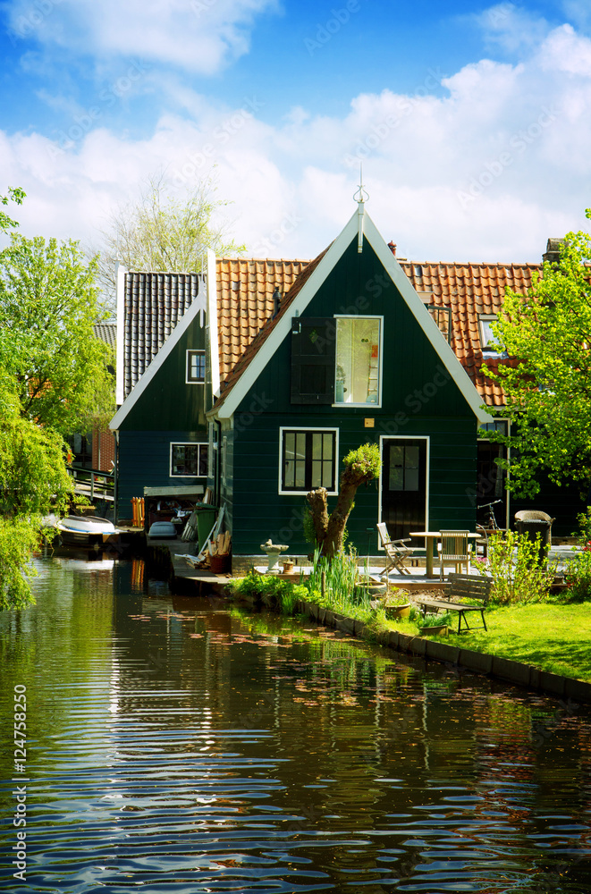 Obraz premium rural dutch scenery of small old houses and canal in Zaanse, Netherlands, retro toned