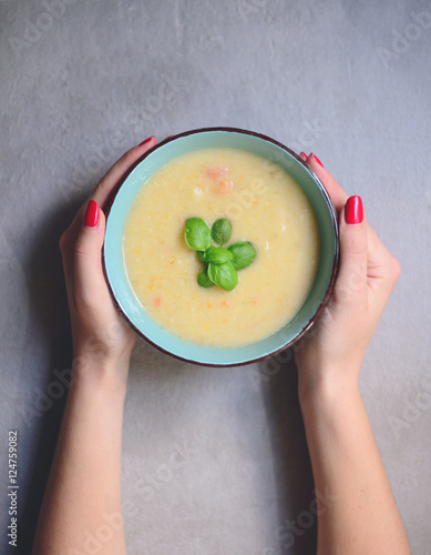 Woman hands holding bowl with home made vegetable soup - Healthy photo