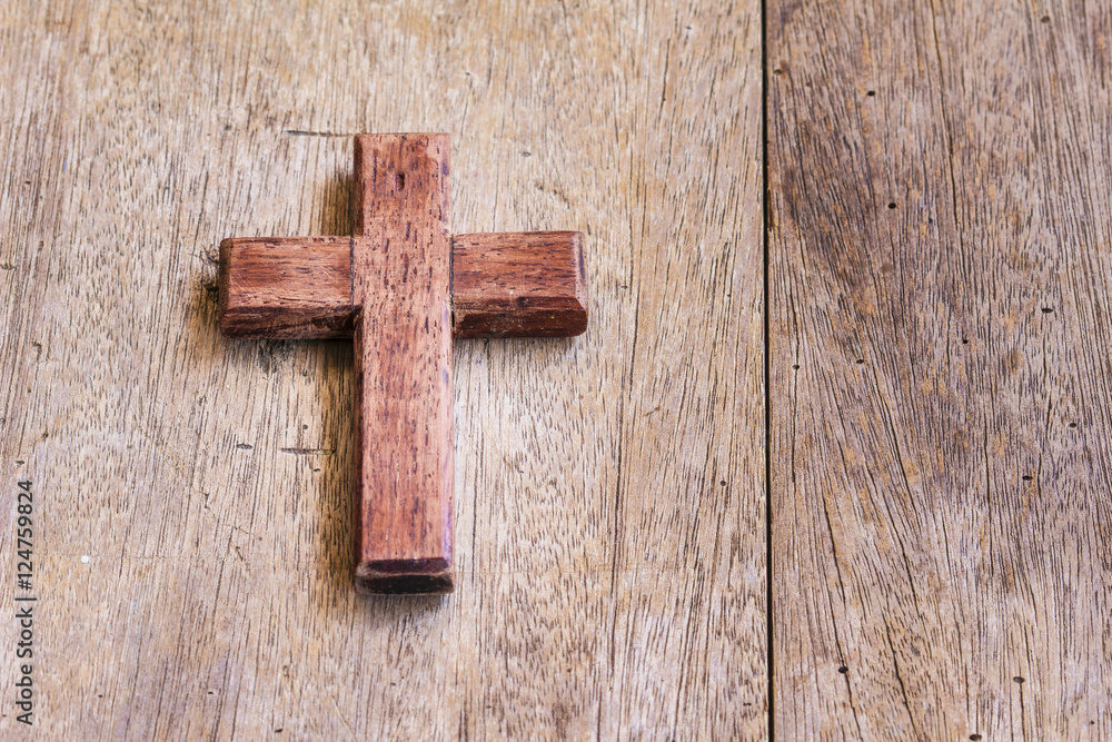 the wooden cross on wooden background with copy space