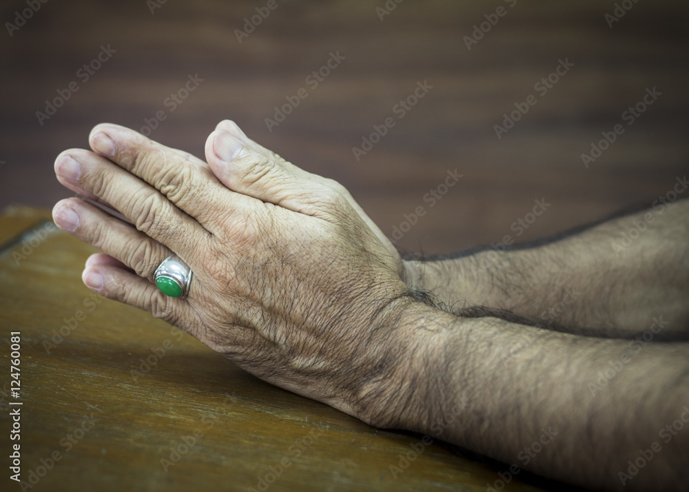 Fototapeta premium man hands praying to God on wooden background