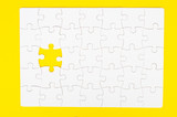 White, disassembled puzzle. On a yellow background.Top view. Flat lay.