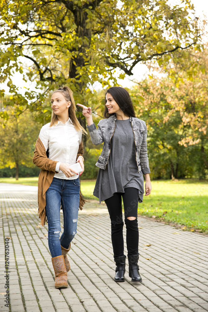 Young girls in the park, walking trail. One other point the finger. Young girls in the park, walking trail. One other point the finger.