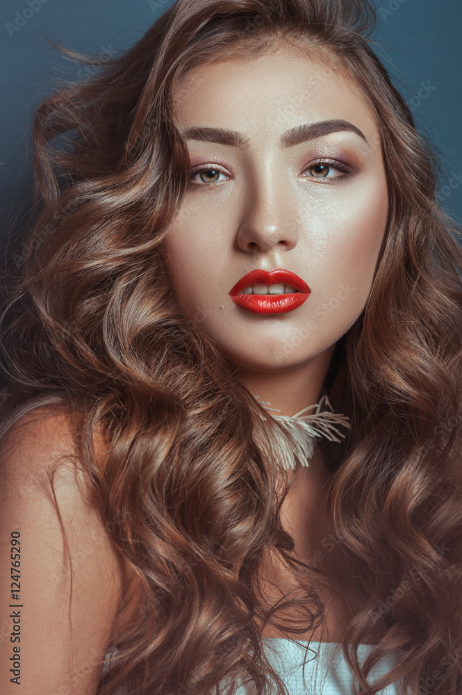 Fototapeta premium Beautiful caucasian girl with curly long hair and luxury makeup with accessories on a neck