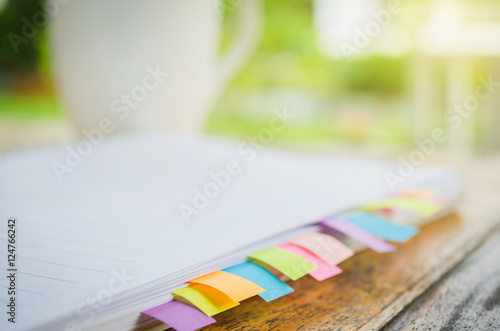 blank note book with colorfull post it on wood table photo