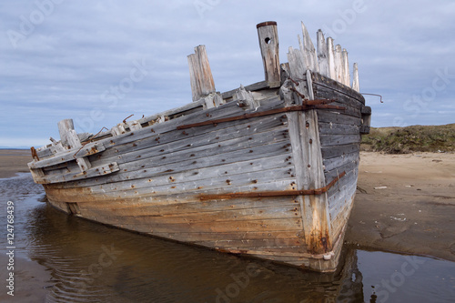 Old wooden ship stranded on a sandy beach. Laptev sea. Yakutia. Russia.
