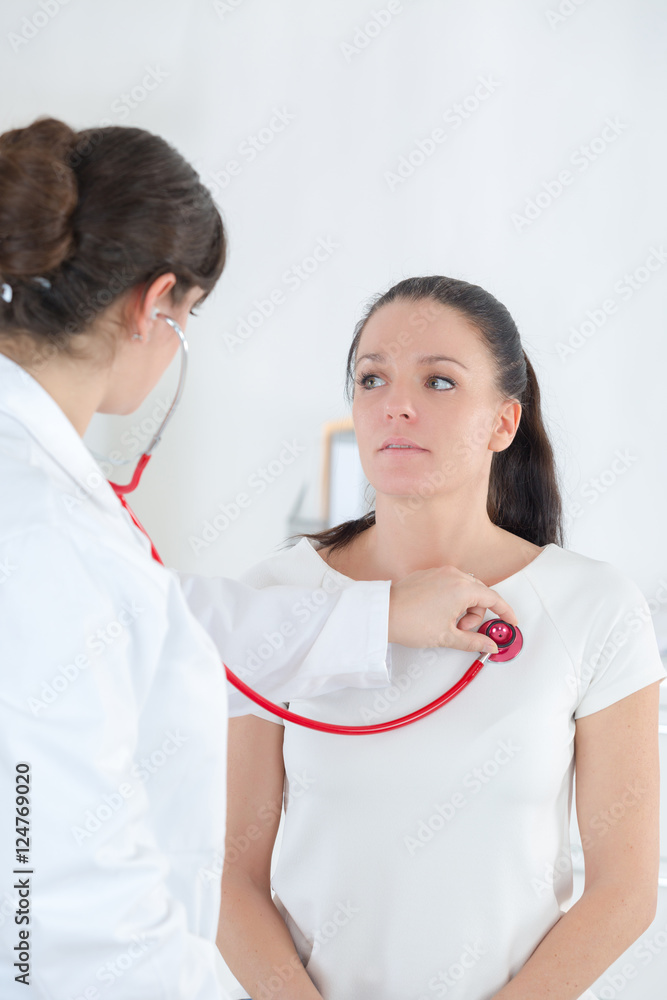 female doctor ausculting patient with stethoscope female doctor ausculting patient with stethoscope