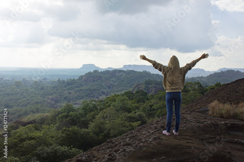 woman standing on the top of the mountain