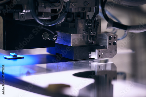 maquina de precisiòn colocando una pieza en una luna de coche