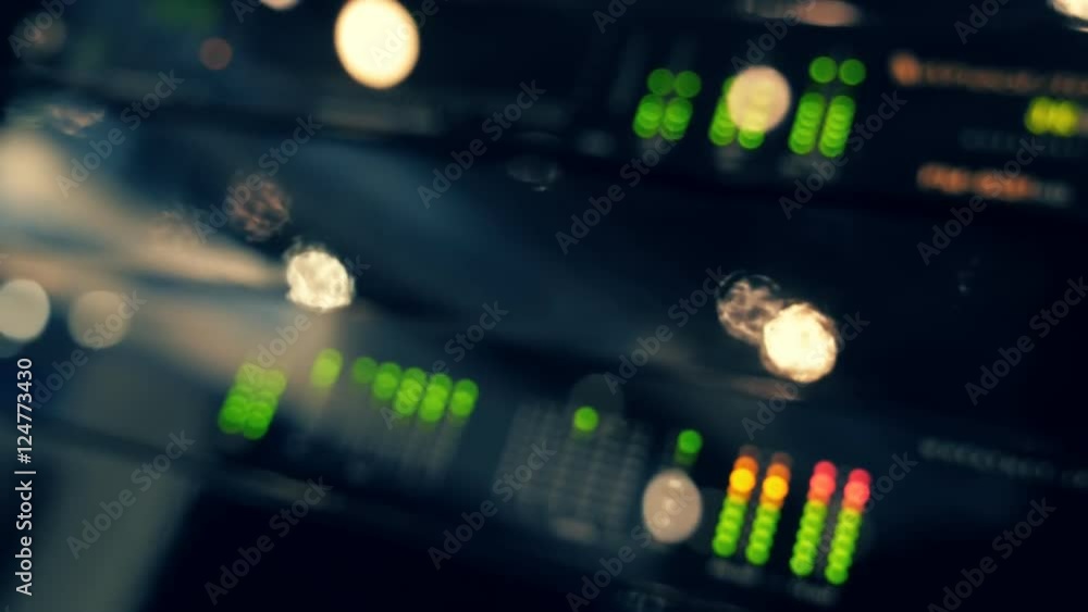 Professional audio-video equipment works, and illuminated a lots of lights and reflections. Video image in defocus. Dolly shot