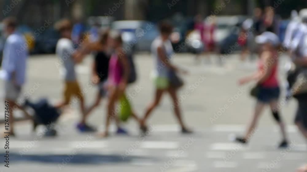 Side view blurred pedestrians crossing a street in the city of Barcelona in summer.Time lapse Side view blurred pedestrians crossing a street in the city of Barcelona in summer.Time lapse