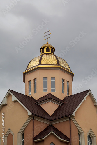 Golden domes orthodox church with cross against blue sky