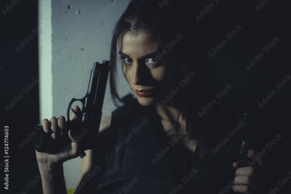 brunette girl with gun in a garage in attitude shoot, dressed in brunette girl with gun in a garage in attitude shoot, dressed in