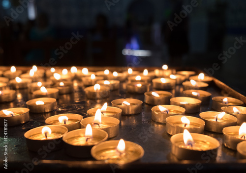 Obraz na plátně lit votive candles in church on black background
