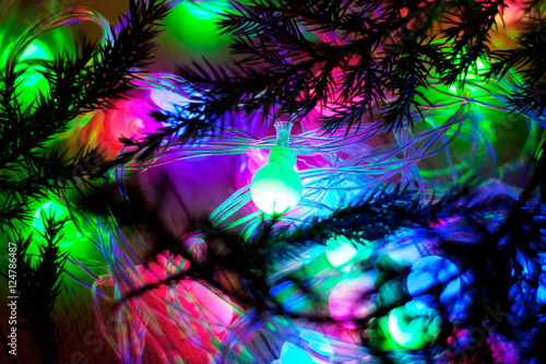 out of focus colored lights and garlands of Christmas tree branc