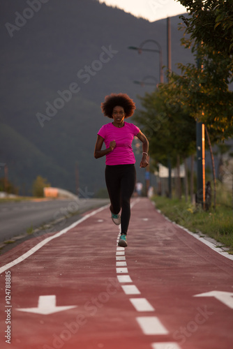 a young African American woman jogging outdoors © .shock