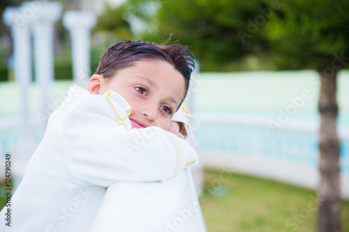 Wallpaper Mural Young First Communion boy smiling and leaning on a white wooden Torontodigital.ca