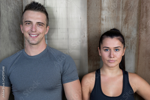 Fit couple after exercise at crossfit gym against rustic backgro