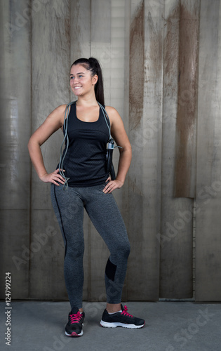 attractive woman with jumping rope against rustic background