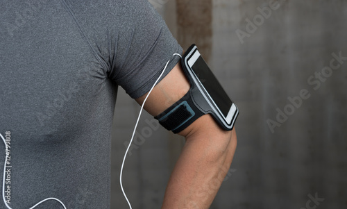close up of man runner listening to music. Muscular male model w