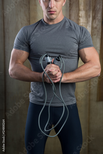 Muscular man skipping rope. Portrait of muscular young man exerc photo