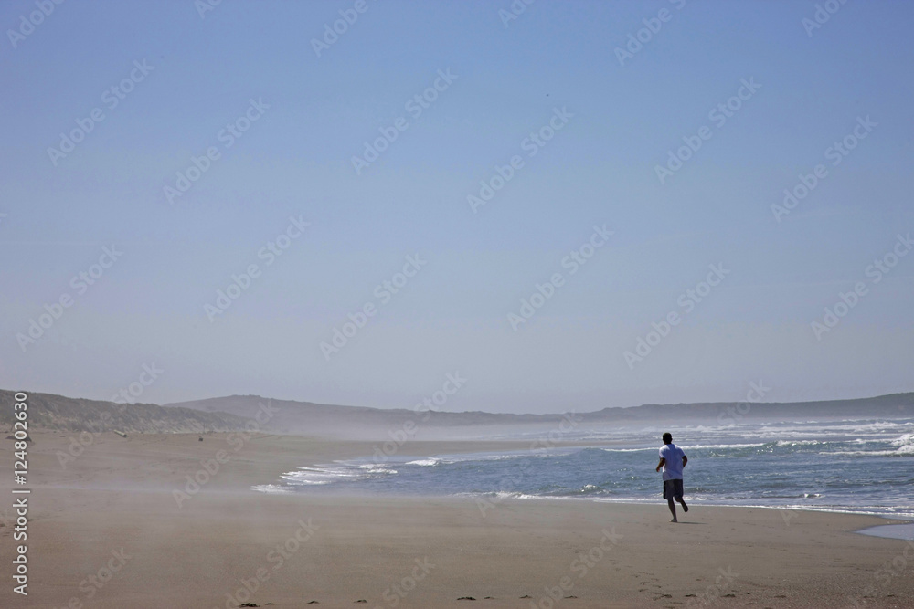 man running on wide beach
