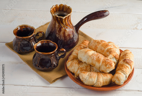 coffee composition with croissants, set on wooden table