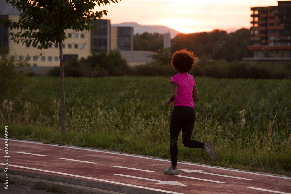 a young African American woman jogging outdoors