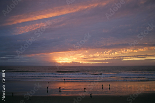 Fotografía ppl on beach w ocean sunset