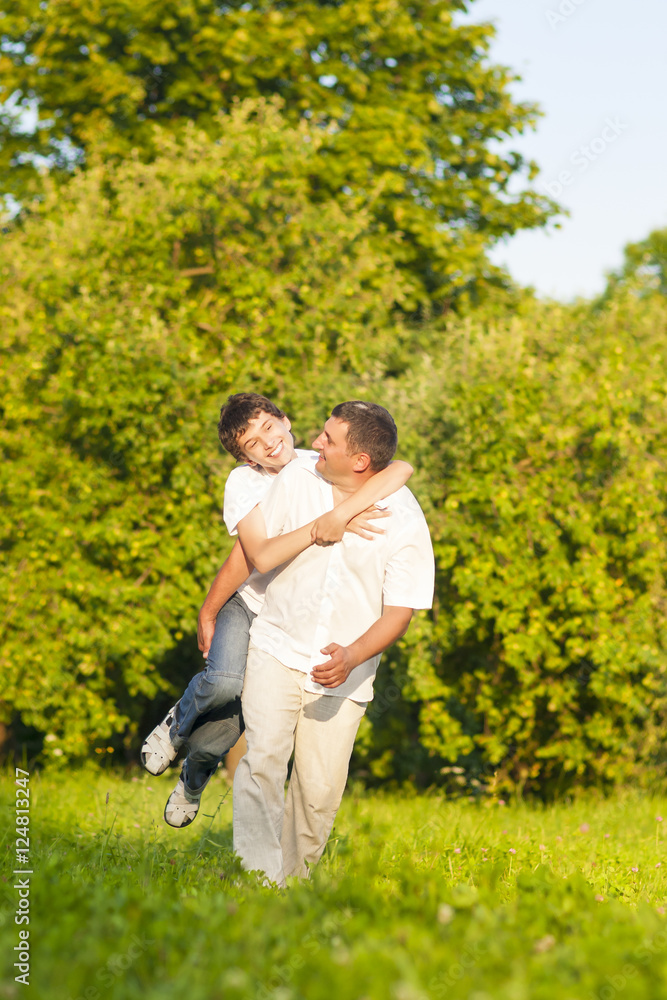 Fototapeta premium Family Values Concepts and Ideas. Happy Caucasian Family of Father and His Son Having Fun Time Together Piggybacking