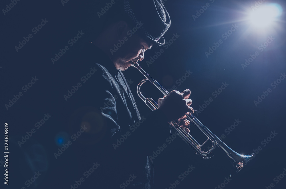 Obraz premium Musician playing the Trumpet with spot light and len flare on th