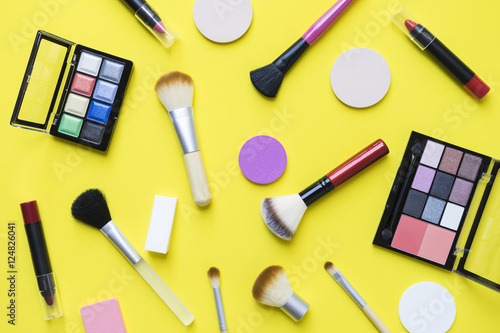 Set of colorful cosmetics on yellow background