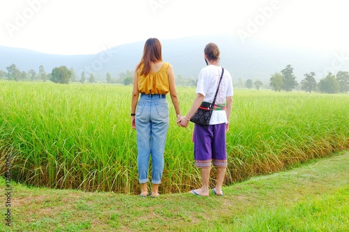 Couples holding hands in the rice fields. Romantic young couple in love. Romantic couple relaxing in field