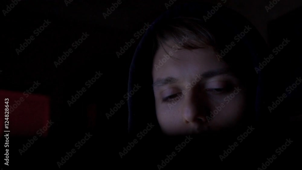 Hacker in hood cracking code using computers in dark room close up Hacker in hood cracking code using computers in dark room close up